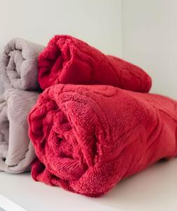 a pile of red and white towels on a bed at Estúdio Fit Caiobá: aconchegante e bem equipado. in Matinhos