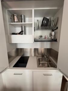 a kitchen with white cabinets and a sink at M14 Duomo Apartments in Padova