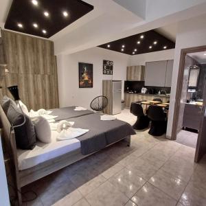 une chambre avec un grand lit et une cuisine dans l'établissement Kakovatos Family Homes, à Zakharo