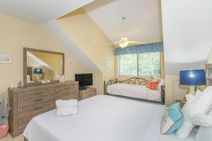 a bedroom with two beds and a television in it at Spacious 2 Bedroom Condo- Vaulted Ceilings and Fireplace- St James Park 12-E in Myrtle Beach