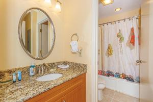 a bathroom with a sink and a toilet and a mirror at Spacious 2 Bedroom Condo- Vaulted Ceilings and Fireplace- St James Park 12-E in Myrtle Beach +31 photos