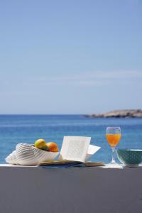 a table with a book and a glass of wine at Apleton Beach House Kimolos at Zacharias Beach in Kimolos