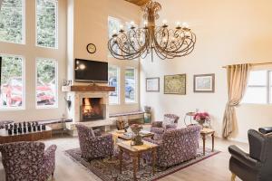 a living room with a chandelier and a fireplace at Kaliman Pousada Campos do Jordão - prédio Luxo in Campos do Jordão