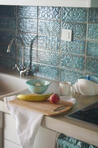 a cutting board with a banana and apples on a kitchen counter at Apleton Beach House Kimolos at Zacharias Beach in Kimolos