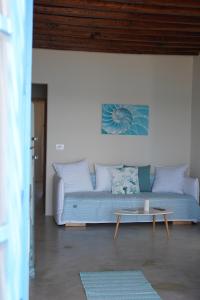 a living room with a blue couch and a table at Apleton Beach House Kimolos at Zacharias Beach in Kimolos