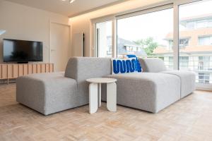 a living room with a couch and a table at -Stay- at Oostduinkerke in Oostduinkerke