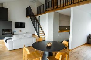 a living room with a table and chairs and a staircase at Tavarneta Estate in Dobrovo