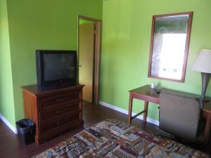 um quarto com uma televisão numa cómoda e uma secretária em Park Motel em Studio City