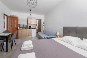 a bedroom with a bed and a kitchen with a table at Utopia suites 3 in the heart of Aegina by 8essentially in Aegina Town