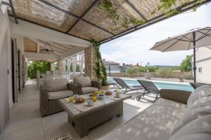 an outdoor patio with a table and chairs and a pool at Villa Batelica with large garden, kids playground and private pool in Labin