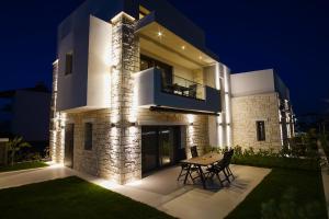 a house with a table in front of it at night at Chora Luxury Suites in Paralia Dionysiou