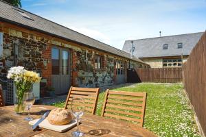 ein Holztisch mit einer Vase mit Blumen darauf in der Unterkunft Shiloh Cottage in Whitwell