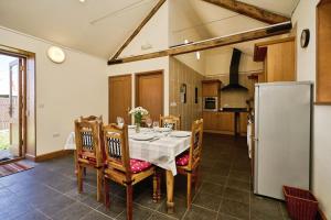 eine Küche mit einem Tisch mit Stühlen und einem Kühlschrank in der Unterkunft Shiloh Cottage in Whitwell + 19 Fotos