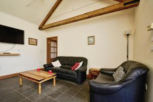 ein Wohnzimmer mit 2 Ledersofas und einem Couchtisch in der Unterkunft Shiloh Cottage in Whitwell