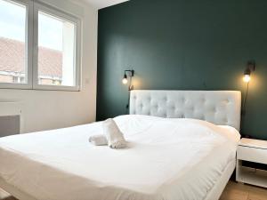 リールにあるLe Royale Vieux Lille appartement 4 voyageursの緑の壁のベッドルームの白いベッド1台