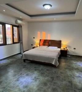 une chambre avec un grand lit et deux lampes dans l'établissement Paramount B&B, à Kinshasa
