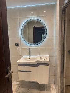une salle de bains avec un lavabo et un miroir dans l'établissement Paramount B&B, à Kinshasa