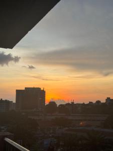 un coucher de soleil sur une ville avec des bâtiments au premier plan dans l'établissement Paramount B&B, à Kinshasa