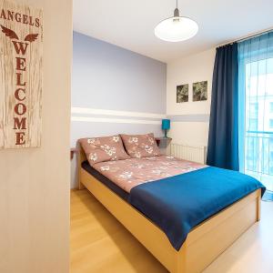 a bedroom with a bed with blue sheets and a window at Lovely home - Free parking in Budapest