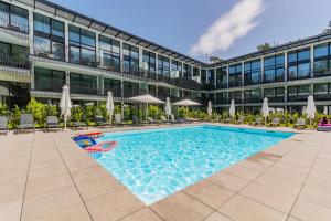 a swimming pool in front of a building at Amber Apartment Forest View in Stegna