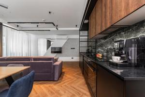 a kitchen and living room with a couch and a table at Amber Apartment Forest View in Stegna