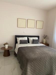 a bedroom with a bed with two pillows and a table at Kyra apartment in Polis Chrysochous