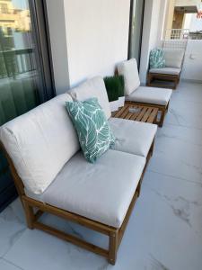 a couch on a porch with two chairs at Kyra apartment in Polis Chrysochous