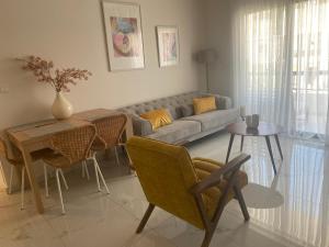 a living room with a couch and a table and chairs at Kyra apartment in Polis Chrysochous