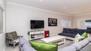 a living room with a couch and a tv at 147 Abalone-Inn in Hermanus