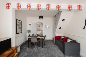 a living room with a table and a couch at Beatles Themed Home near Anfield, sleeps 7, Garden, Contractors, Games in Liverpool