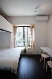a bedroom with a bed and a window and a table at ハーモニーヒルズVilla箱根強羅 in Hakone