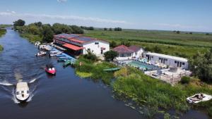 an aerial view of a resort on a river with boats at Pensiunea La Miluta in Caraorman