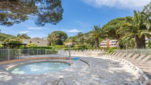 ein kleines Becken mit Stühlen und Bäumen in einem Park in der Unterkunft Résidence Pierre & Vacances L’Anse De Pramousquier in Le Lavandou