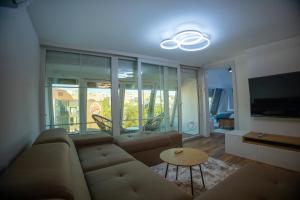 a living room with a couch and a tv at Central Square Apartments in Pristina