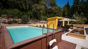 a swimming pool with a patio and a house at Apartmani 3T in Blace