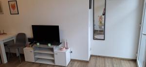 a living room with a television and a desk with a chair at Emsquartier Apartment No 1 in Emsdetten +6 photos