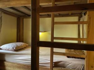 two bunk beds in a small room with a bed at Social Ducks Hostel Borobudur in Borobudur