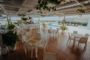 a restaurant with tables and chairs and a pool at Curacao Airport Hotel in Willemstad