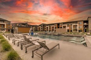 una piscina con tumbonas frente a un edificio en Furnished Executive 3-bed 2-bath Apartment Wichita Kansas, en Wichita