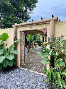 a garden entrance to a building with a wooden door at Social Ducks Hostel Borobudur in Borobudur