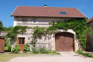 a house with two garage doors and a building at Gite Mentrel in Champ-le-Duc