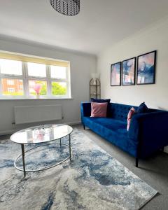 un salon avec un canapé bleu et une table dans l'établissement Sunderland City Centre Modern 2 Bed Apartment, à Sunderland