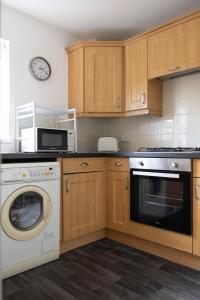 Il comprend une cuisine équipée d'une cuisinière, d'un lave-vaisselle et d'un réveil. dans l'établissement Sunderland City Centre Modern 2 Bed Apartment, à Sunderland