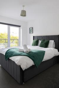 une chambre avec un grand lit avec des oreillers verts dans l'établissement Sunderland City Centre Modern 2 Bed Apartment, à Sunderland