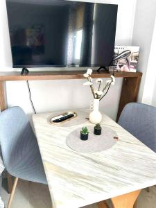a table with two chairs and a vase with flowers on it at Alpha apartment 43 in Serres