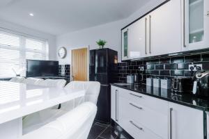 a kitchen with white chairs and a black refrigerator at Rossendale Incredible Home 3Bedrooms Driveway Sleeps 6 in Newchurch