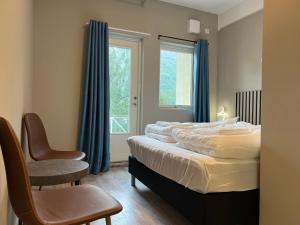 a bedroom with a bed and a chair and a window at Åndalsnes house in Åndalsnes