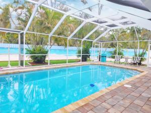 a swimming pool with a white pergola and a swimming pool at 5 Bed Heated Pool Largo, Seminole FL 2 mi Indian Rocks Beach , Pets, Game room in Seminole