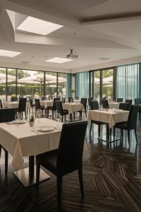 佐拉普雷多萨Amatì Design Green Hotel的有桌椅和窗户的餐厅 更多37张照片