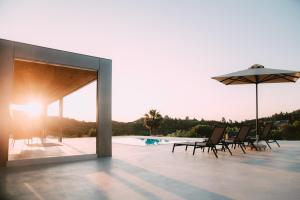 アギア・パラスカヴィにあるThe Mood Residenceのパティオ(椅子、パラソル、プール付)